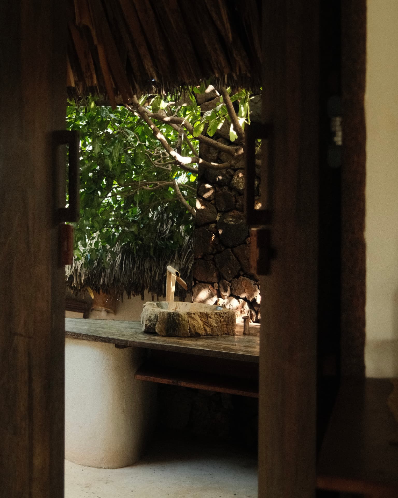 Stone basin vanity framed by a wooden doorway